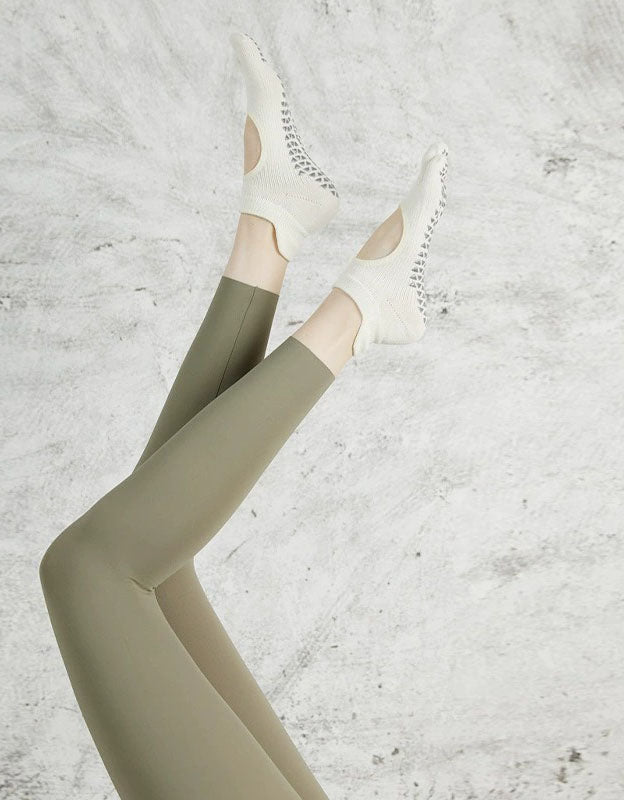 Women wearing non-slip toe yoga socks on mat close-up