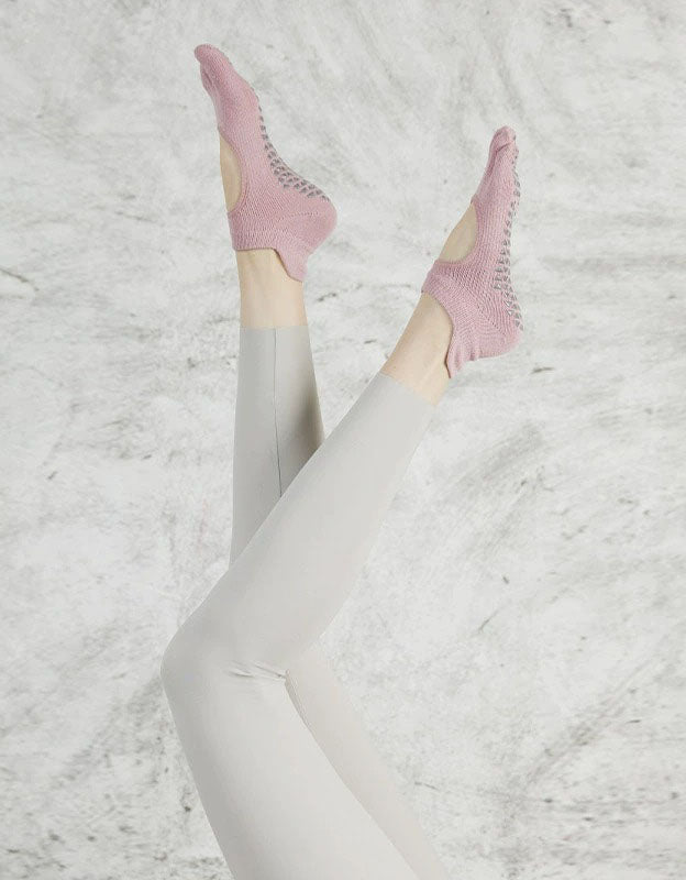 Person wearing pink socks with a textured white background