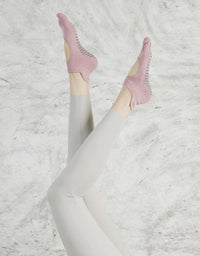 Person wearing pink socks with a textured white background
