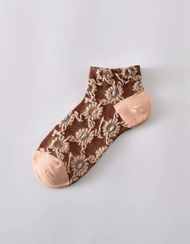 Close-up of floral lace embroidery on transparent mesh socks
