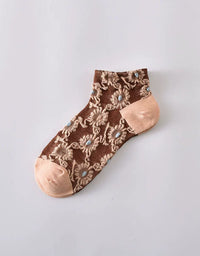Close-up of floral lace embroidery on transparent mesh socks