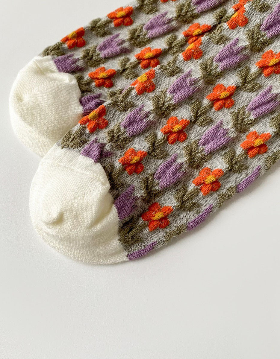 Close-up of floral knit socks with lace trim displayed on table