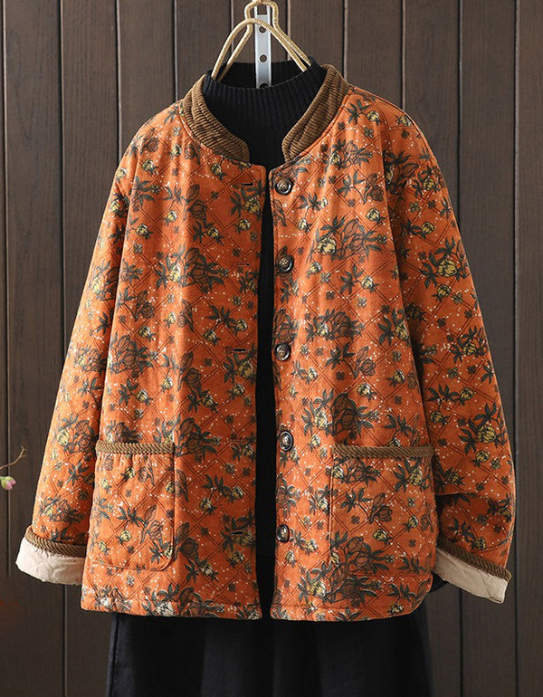 Floral-patterned orange coat hanging against a wooden background