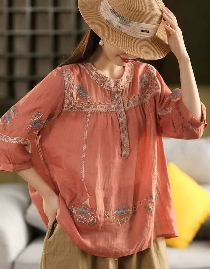 Side view of women’s orange bohemian embroidered cotton blouse with button details