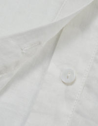 Close-up of a white shirt with a button on a light gray background