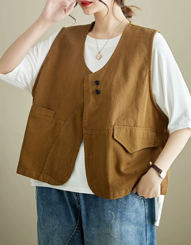 Person wearing a brown vest over a white shirt with blue jeans on a neutral background