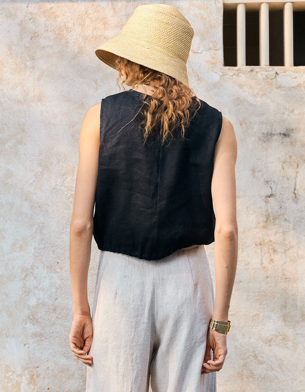 Back view of black minimalist sleeveless linen drawstring crop top women