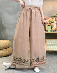 Person wearing beige wide-leg pants with floral embroidery in a casual setting.