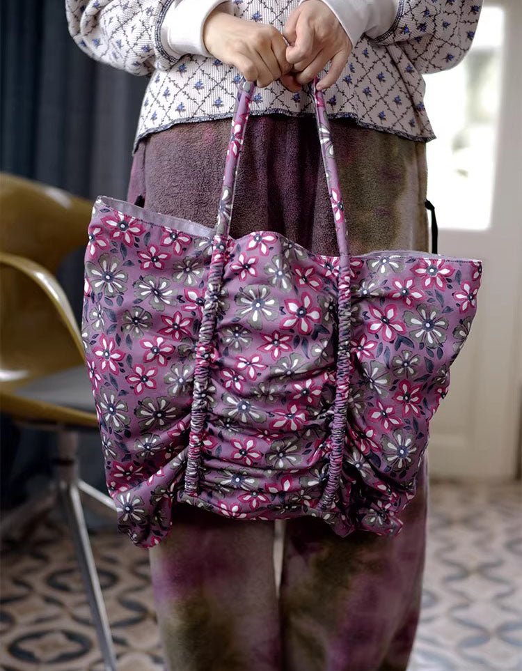 Person holding a floral-patterned bag indoors