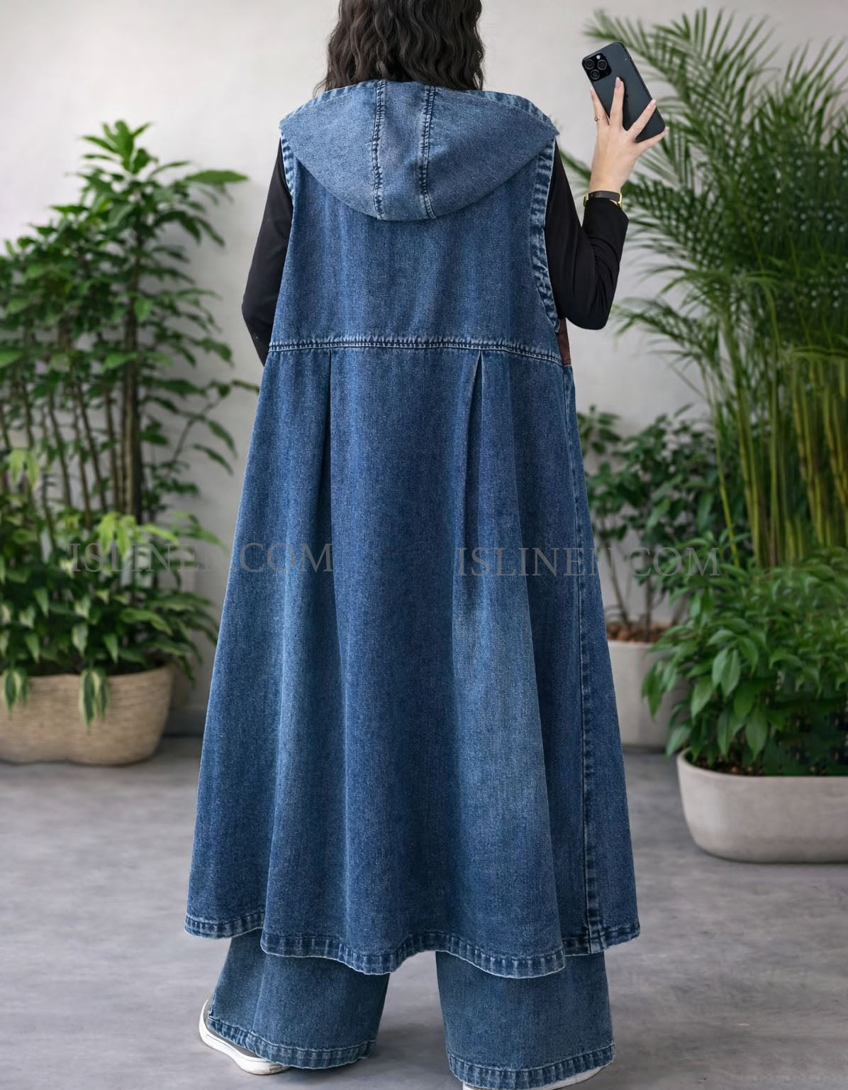 Back view of women’s denim hooded vest with pockets and color block pattern