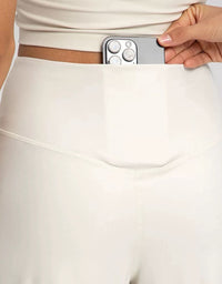 Women wearing beige wide leg pants with a minimalist athleisure outfit