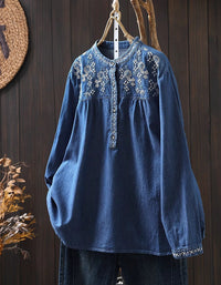 Front view of women's blue embroidered denim shirt with floral design and button-down closure.
