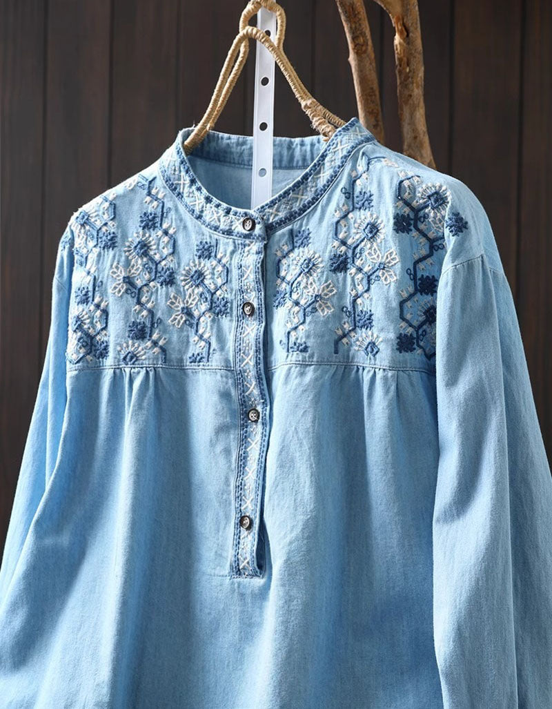 Close-up of the delicate floral embroidery on the women's light blue denim shirt, showcasing the button-down detail.