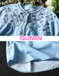 Close-up of button-down women’s denim blouse with unique embroidery accents on the shoulders.