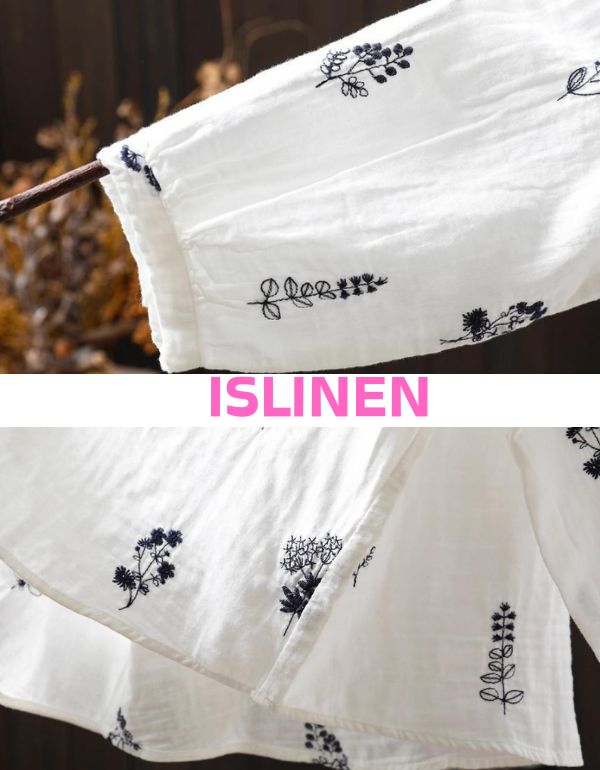 White fabric with black floral embroidery on a wooden stick against a blurred natural background, featuring the brand 'ISLINEN'.
