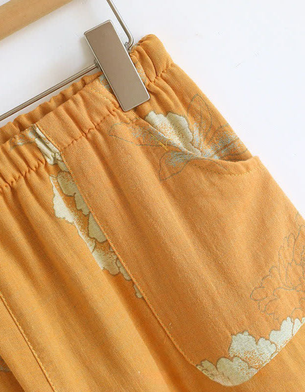 Close-up of the elastic waistband and relaxed fit of the floral embroidered pants in mustard yellow for women