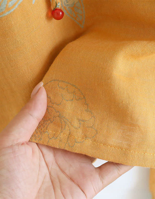 Close-up of the soft cotton fabric texture and floral embroidery on the women’s mustard yellow top