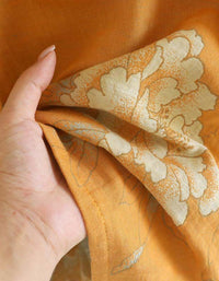 Close-up of the intricate weave of the cotton fabric on the mustard yellow top, showcasing its smooth finish and subtle texture