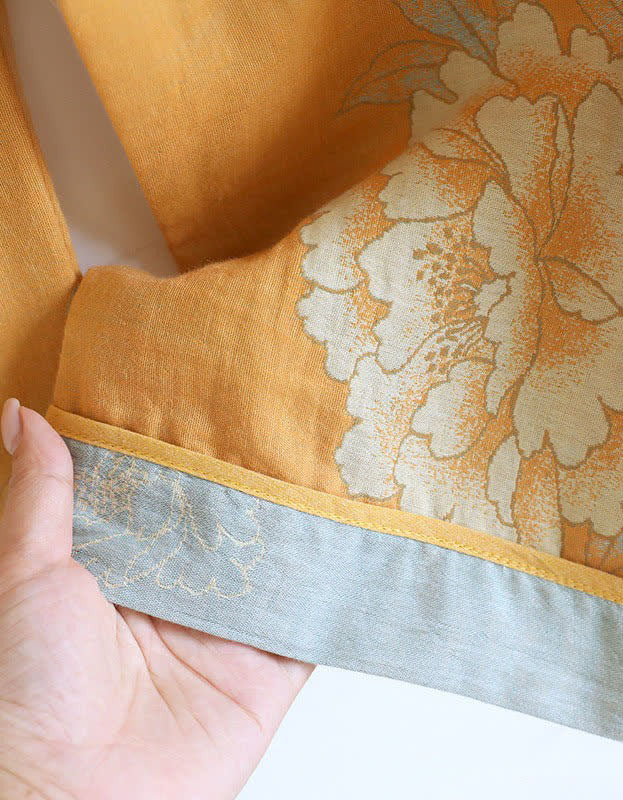 Close-up of the soft, breathable fabric of the mustard yellow floral embroidered top, highlighting its