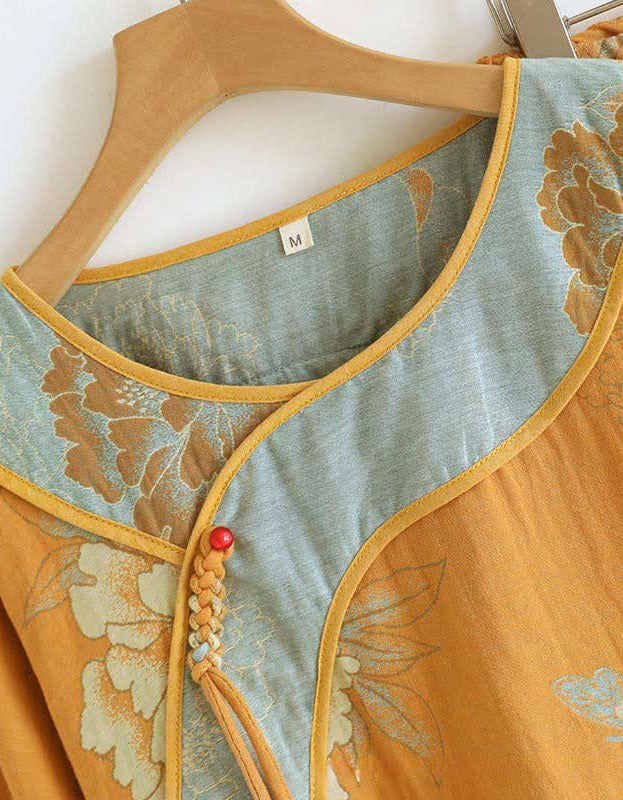 Detailed close-up of the floral embroidery on the women’s top and pants in mustard yellow