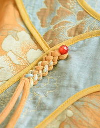 Close-up of floral embroidery on the women’s mustard yellow top, showcasing intricate stitching and vibrant design