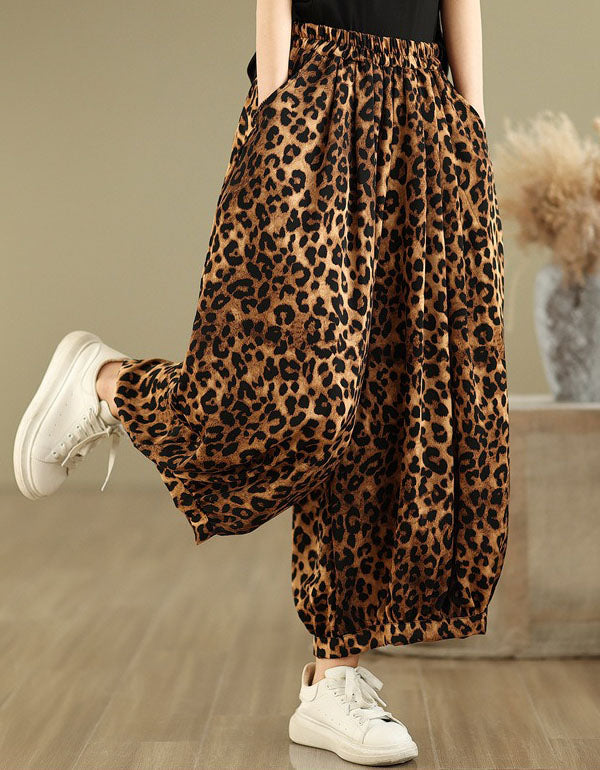 Side view of women’s leopard print wide-leg pants paired with white sneakers.