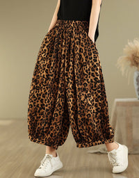 Front view of women’s leopard print wide-leg pants paired with white sneakers.