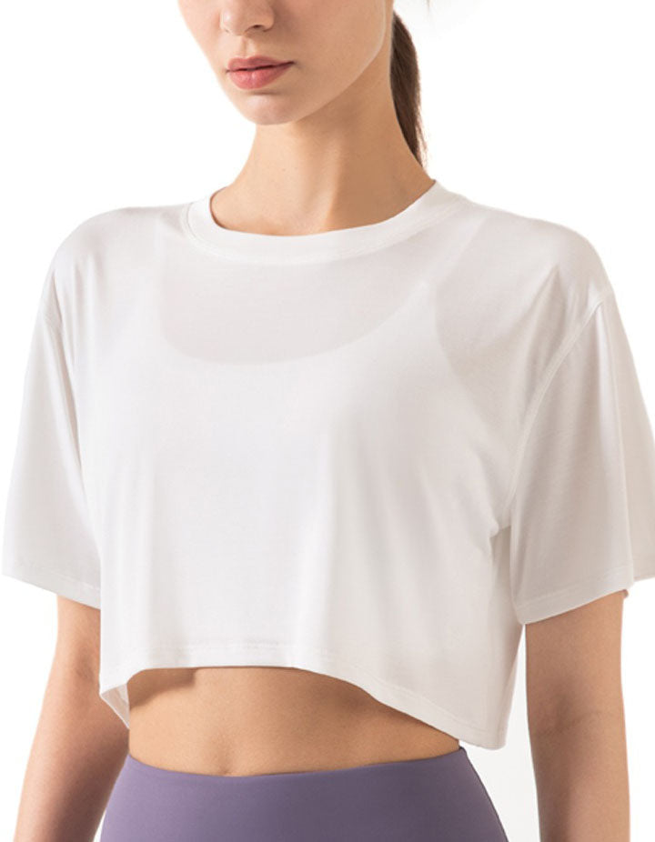 Person wearing a white cropped t-shirt on a plain background