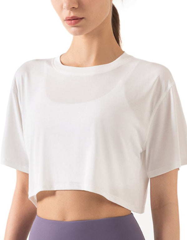 Person wearing a white cropped t-shirt on a plain background