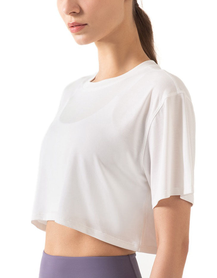 Woman wearing a white crop top with a blurred background