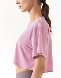 Person wearing a pink athletic top on a white background side view