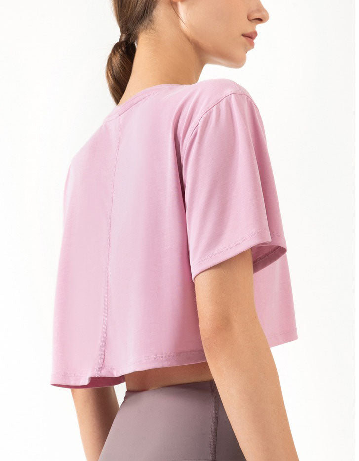 Person wearing a pink athletic top on a white background back view