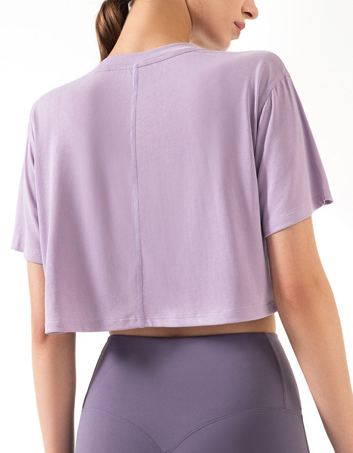 Person wearing a light purple athletic outfit on a white background back view