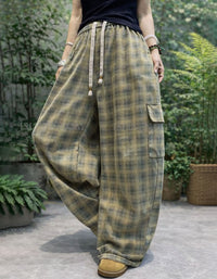 Person wearing plaid wide-leg pants with a garden background