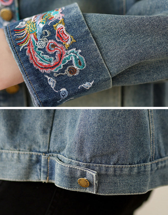 Close-up of a denim jacket with embroidered cuffs and button details.