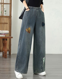 Side view of women wearing wide-leg denim pants with elastic waist