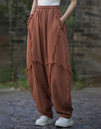 Person wearing brown layered pants with a blurred stone wall background
