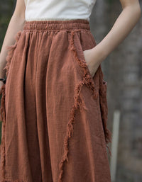 Brown frayed skirt worn by a person with a blurred natural background