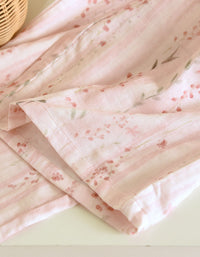 Folded pink fabric with floral pattern on a light green background