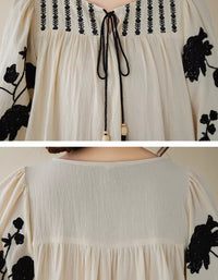 Close-up of black floral embroidery on boho dress sleeves