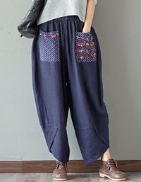 Front view of women’s navy wide-leg pants with floral pocket details.