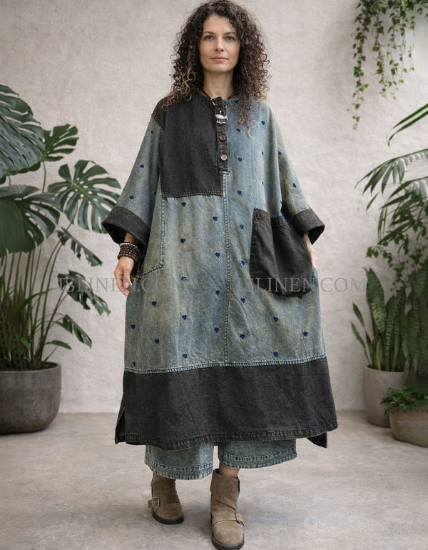 Oversized heart print patchwork denim maxi coat dress with dark yoke and large front pocket, worn over cropped jeans and boots.
