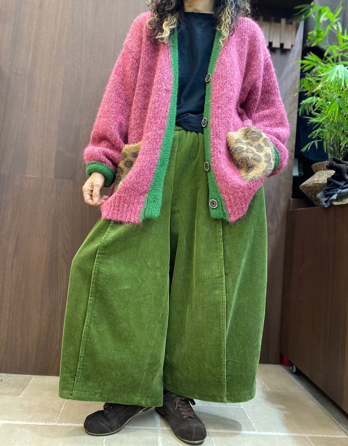 Green knit button placket with grey buttons on pink V-neck cardigan