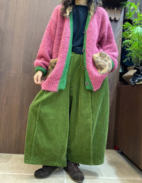 Green knit button placket with grey buttons on pink V-neck cardigan