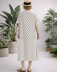 Back view of loose fit cream polka dot midi dress with short sleeves and mid‑calf length.
