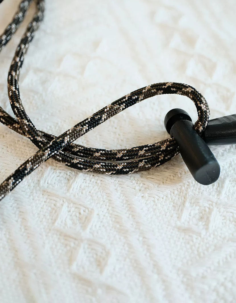 Black earbud on a textured white surface
