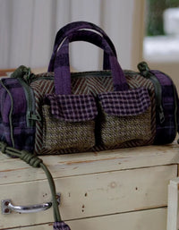 Handbag with purple and green plaid pattern on a wooden surface