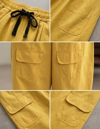 Detail shot of the adjustable black drawstring and elastic waistband on yellow pants.