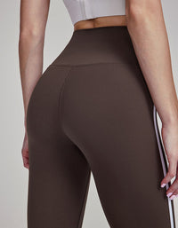 Brown leggings worn by a person on a plain background back view