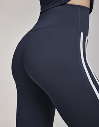 Dark gray leggings with a white stripe on a neutral background back view